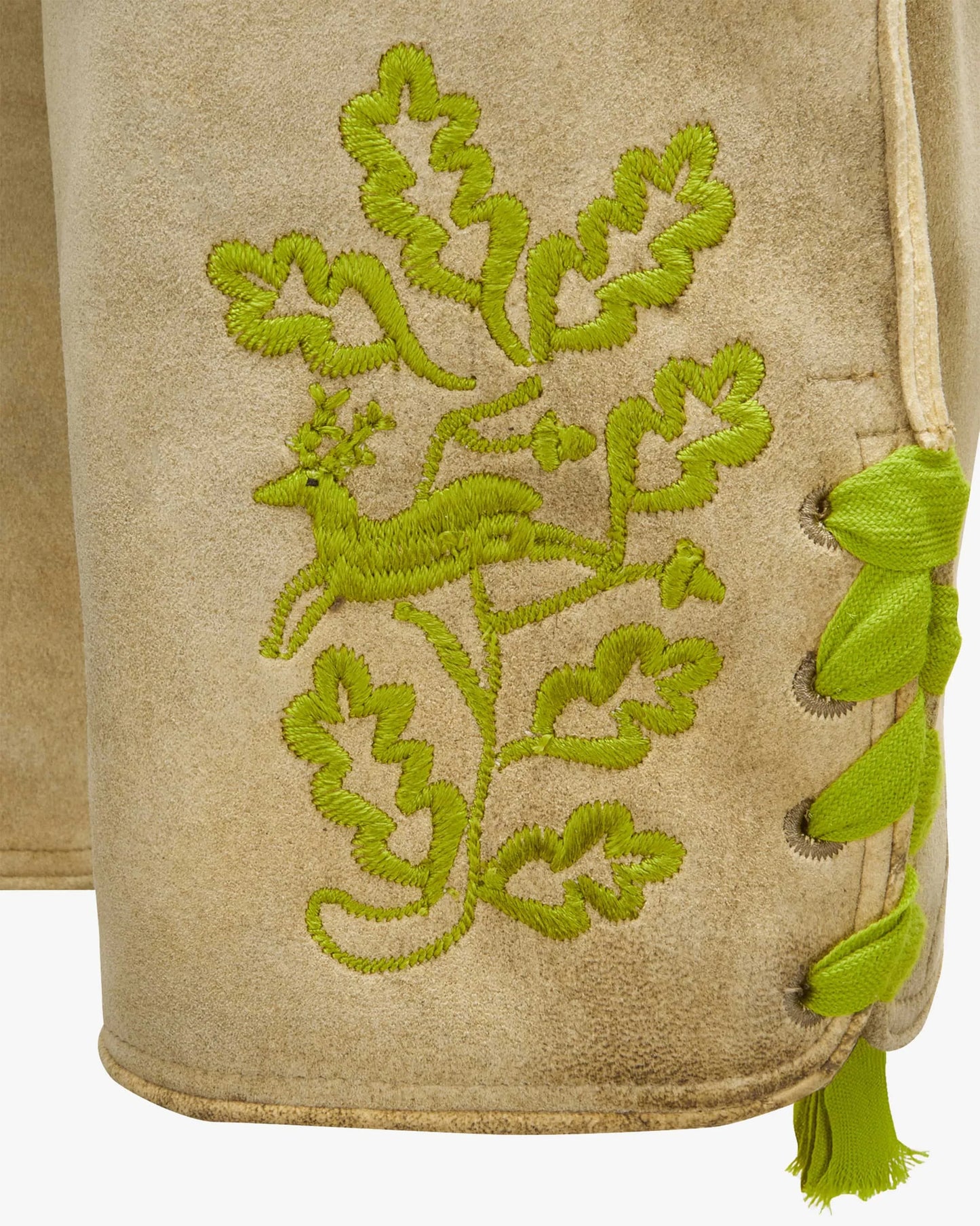 Beige fabric with green embroidered design of a deer and foliage.