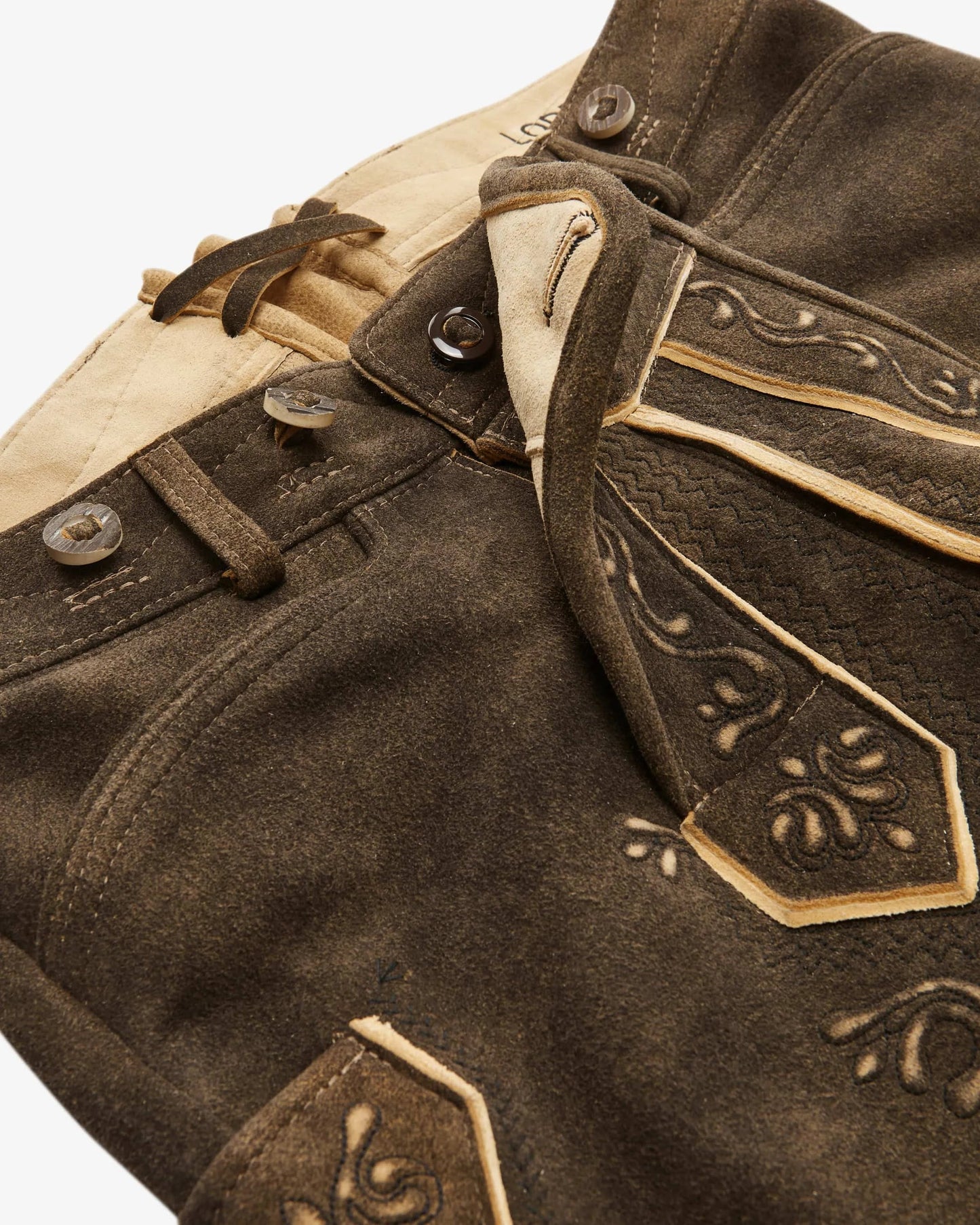 Close-up of a brown leather jacket with decorative stitching on a white background