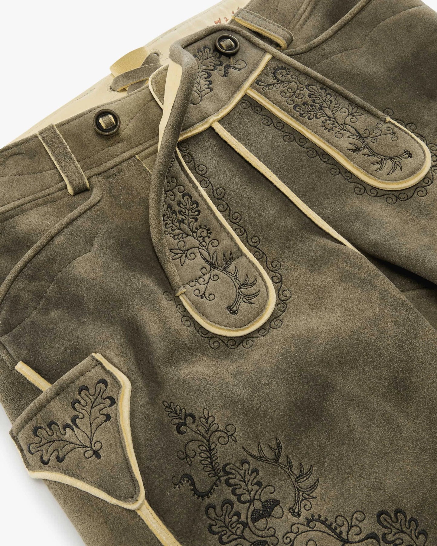 Brown leather pants with decorative stitching on a white background