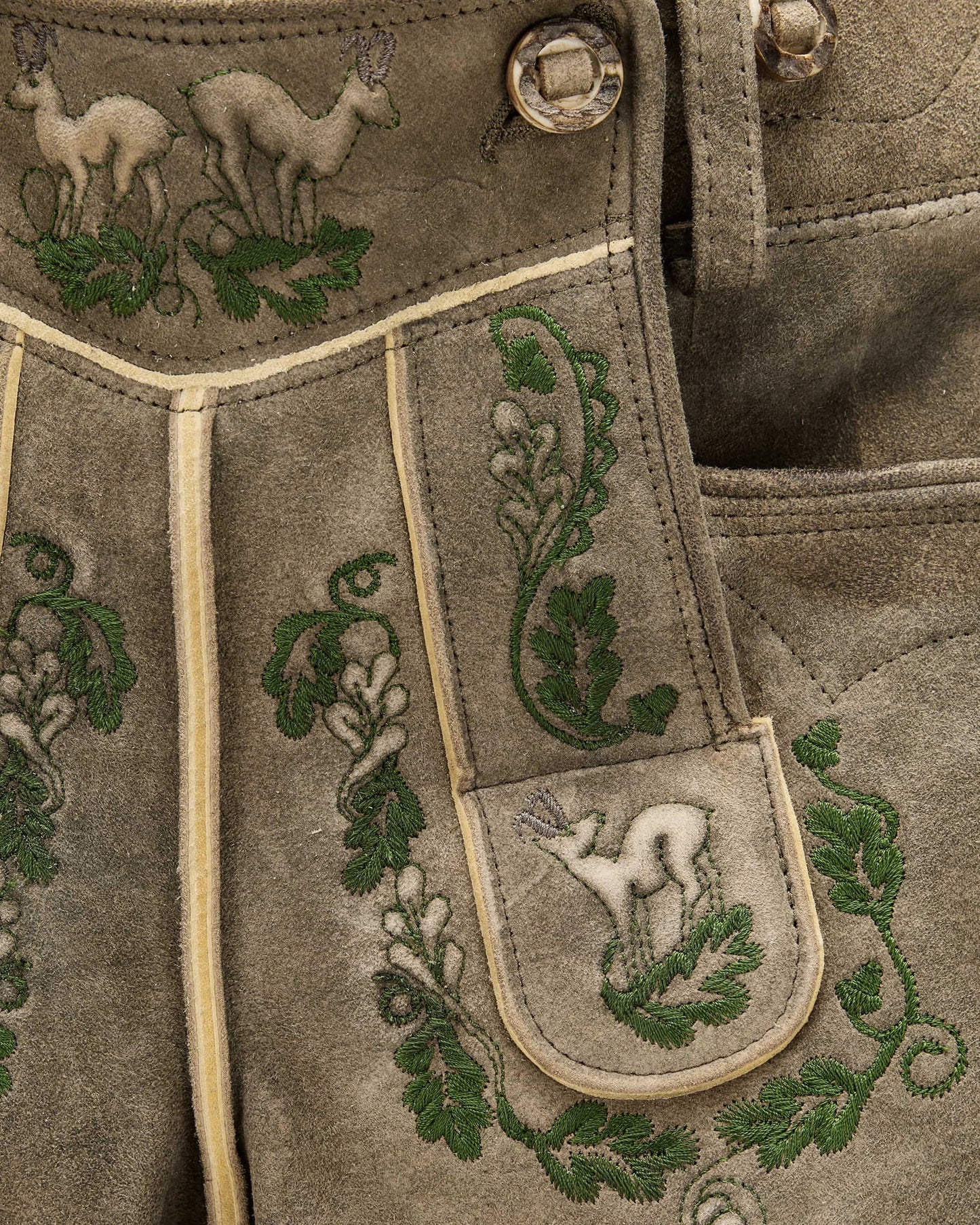 Embroidered fabric with deer and leaf patterns on a brown background