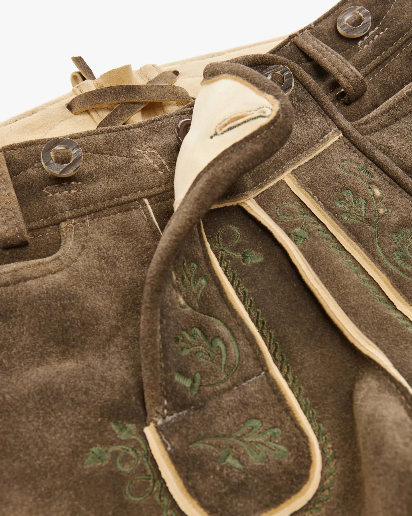 Brown leather jacket with green embroidery and beige trim on a white background