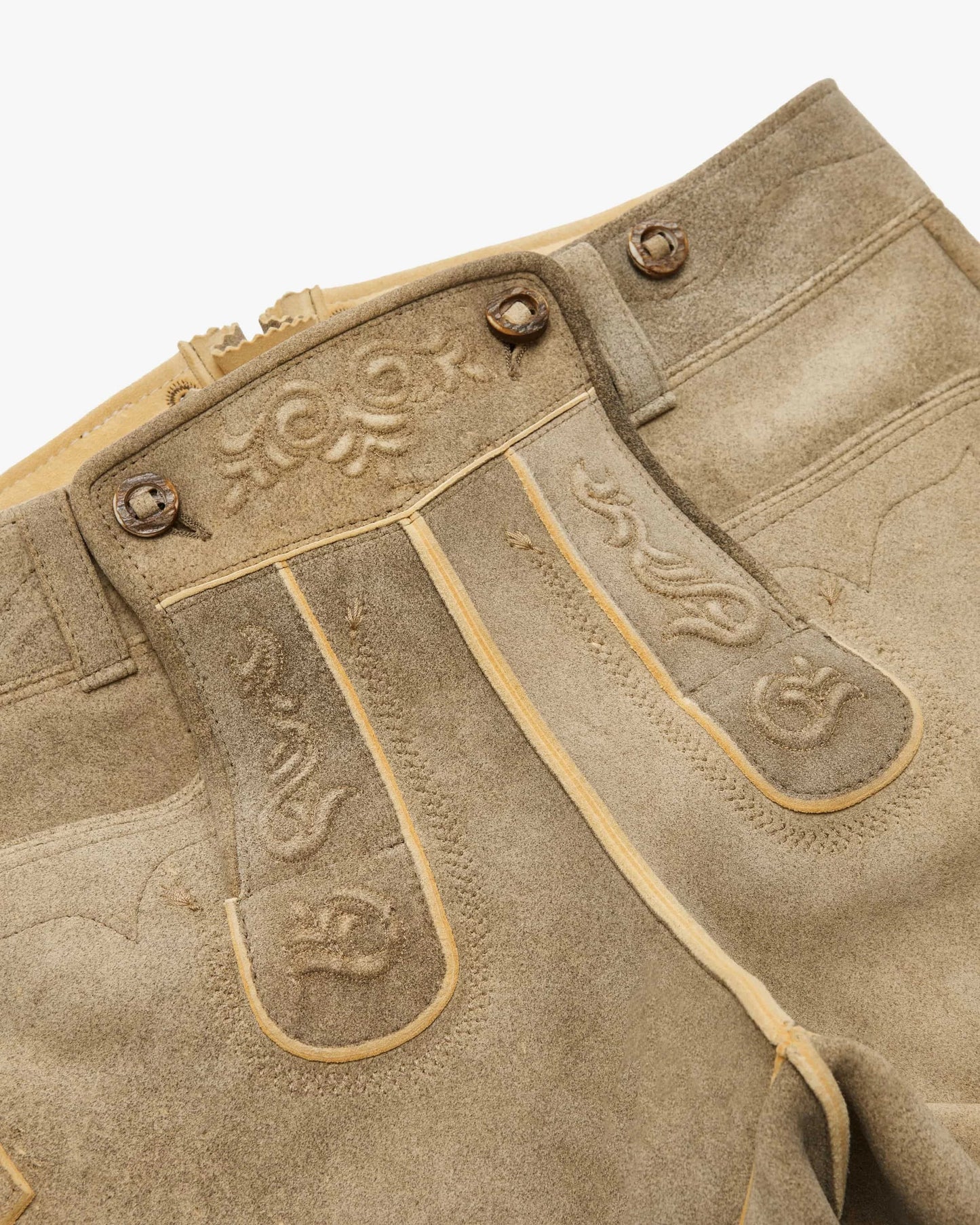 Close-up of a brown leather boot with decorative stitching on a white background
