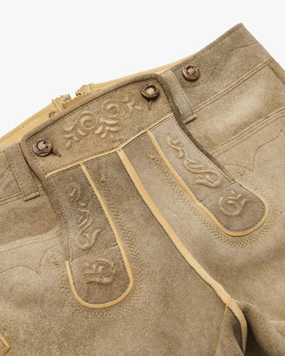 Close-up of a brown leather boot with decorative stitching on a white background