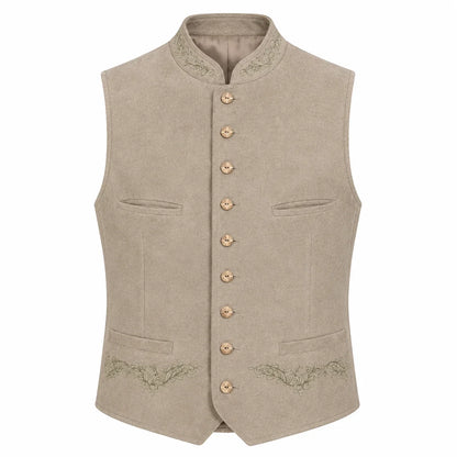 A light beige traditional German waistcoat (Mantel) with a mandarin collar, gold-tone buttons, and subtle green embroidery on the pockets and lower front, shown against a plain white background.