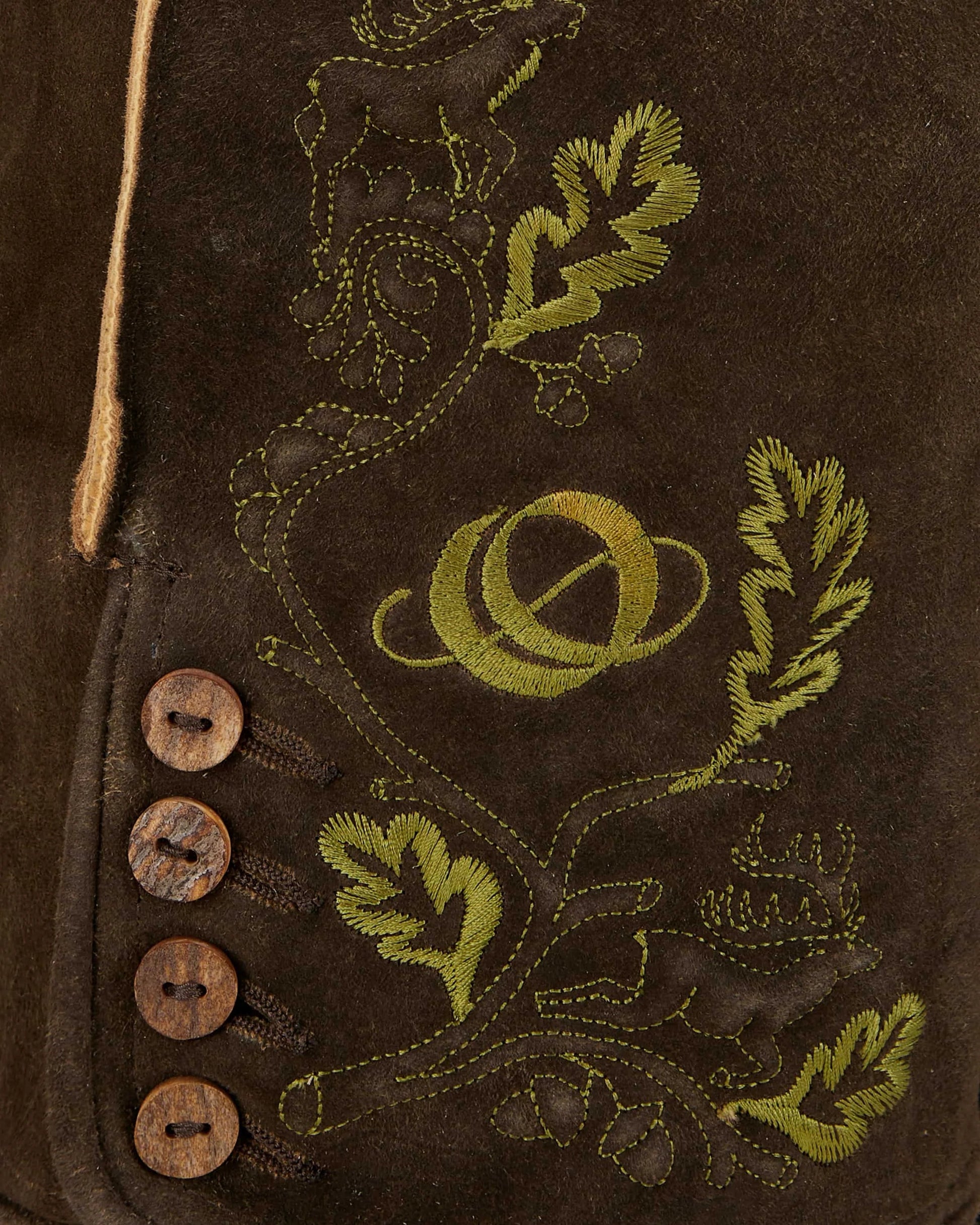Close-up of brown leather jacket with green embroidery and buttons.