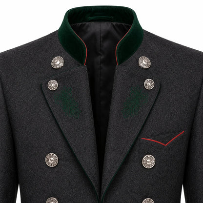 Close-up of a dark gray textured double-breasted coat with a green velvet collar, silver buttons, and red piping details.