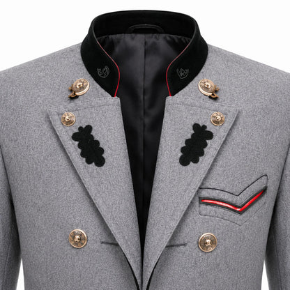 Close-up of a gray military-style double-breasted blazer with black peak lapels, gold buttons, black embroidered insignia, and red piping details on the pocket and collar.