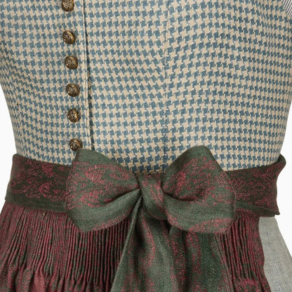 Close-up of a patterned garment with buttons and a bow tie on a white background
