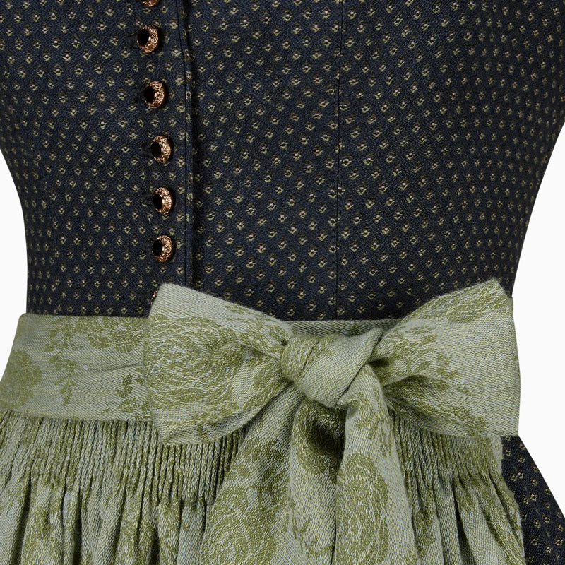 Close-up of a dark blue patterned top with a green floral skirt and ribbon.