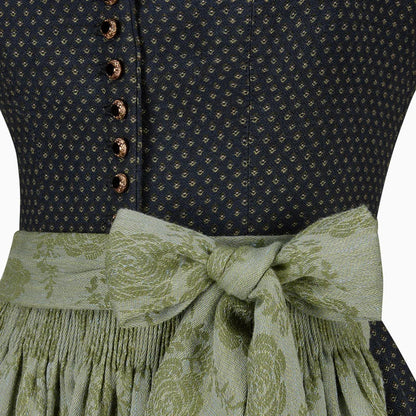 Close-up of a dark blue patterned top with a green floral skirt and ribbon.