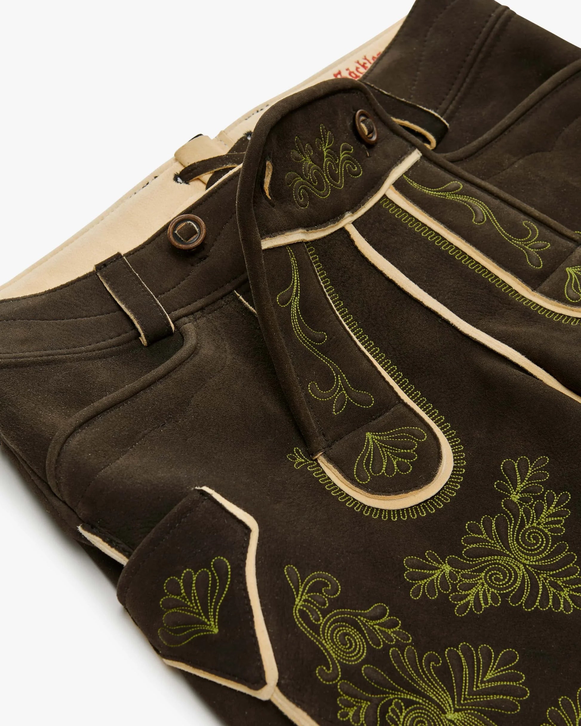 Brown pants with green embroidery on a white background
