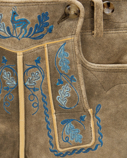 Brown fabric with blue embroidered patterns on a close-up shot