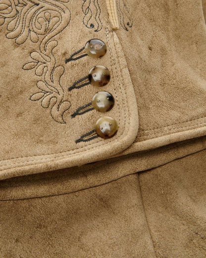 Close-up of a brown leather jacket with decorative stitching and buttons.
