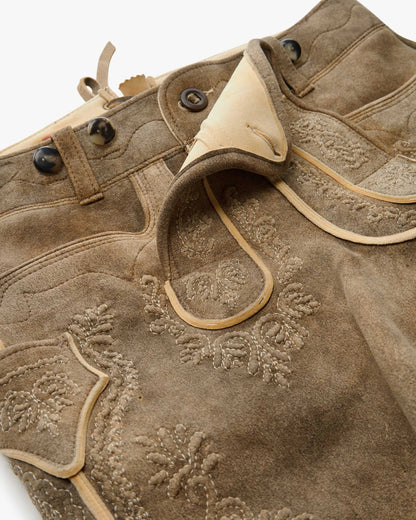 Close-up of a brown leather jacket with floral embroidery on a white background