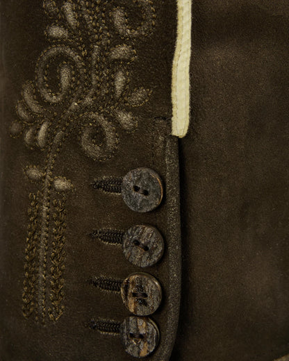 Close-up of a brown leather jacket with decorative buttons and stitching.