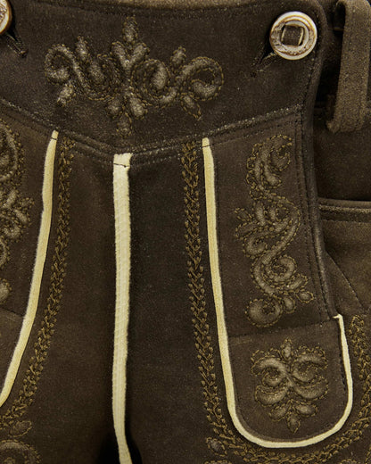 Close-up of brown leather pants with decorative stitching and buttons.