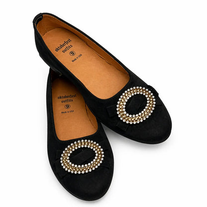 Black flats dirndl shoe with pearl embellishments on a white background