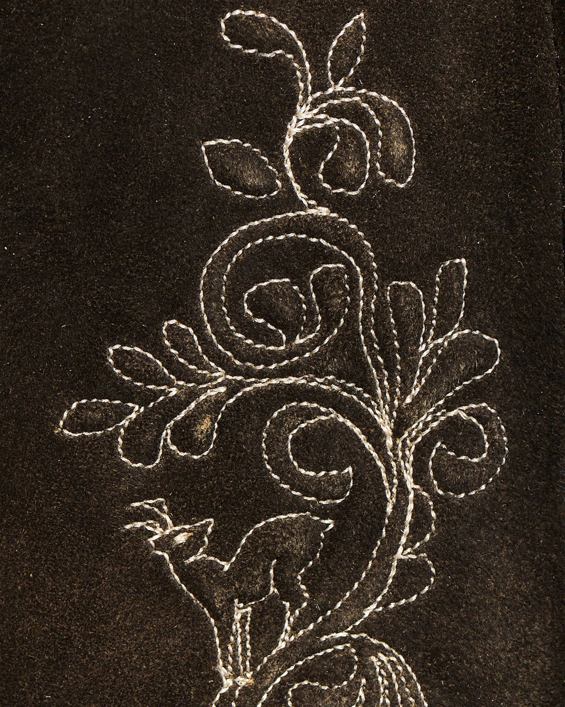 Decorative floral embroidery on a dark fabric background