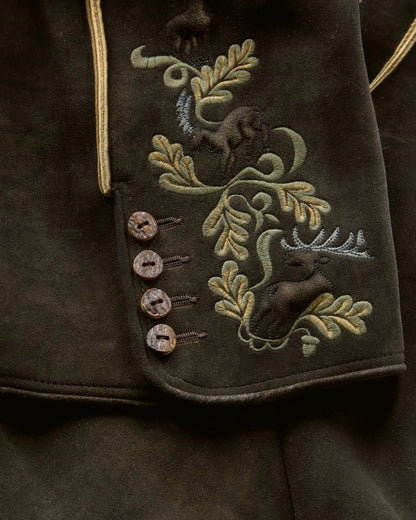 Embroidered design on a dark fabric with deer and foliage patterns.