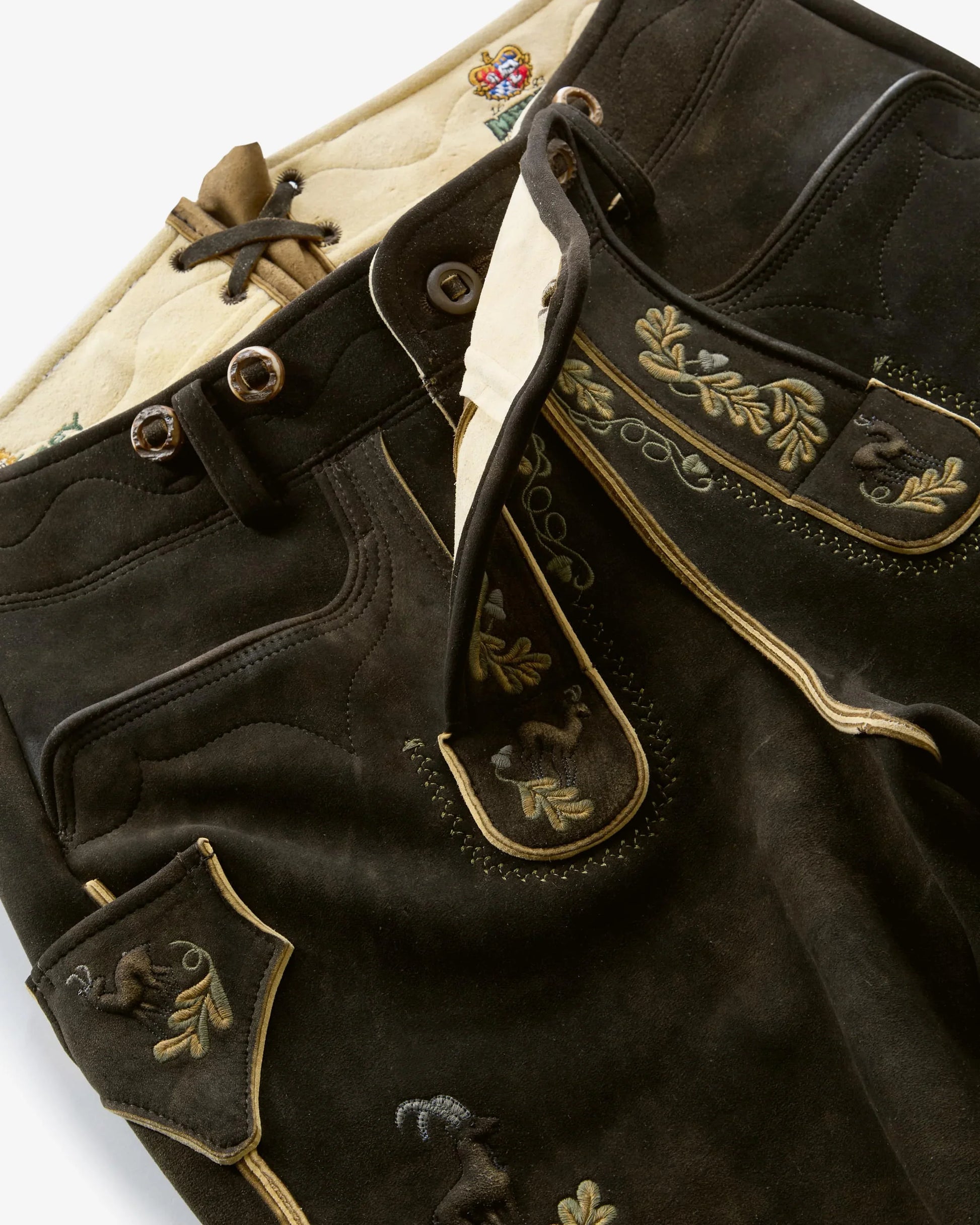 Black leather jacket with gold embroidery on a white background