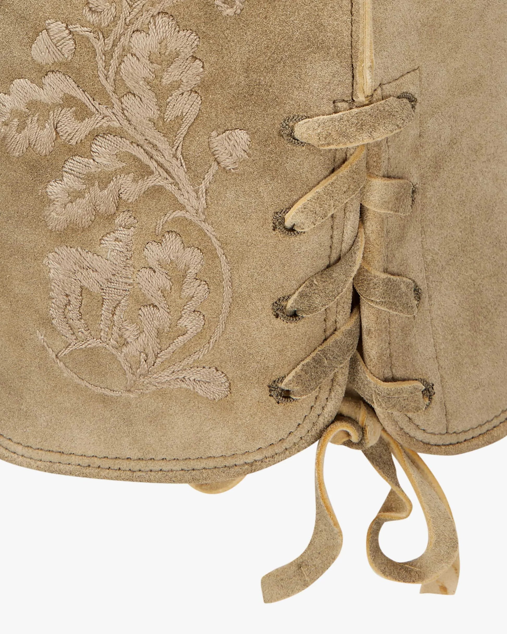 Close-up of a beige leather bag with floral embroidery and decorative lacing on a white background
