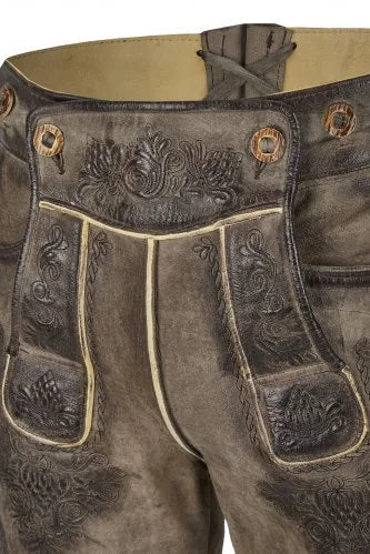 Brown leather pants with intricate designs and buttons on a beige background