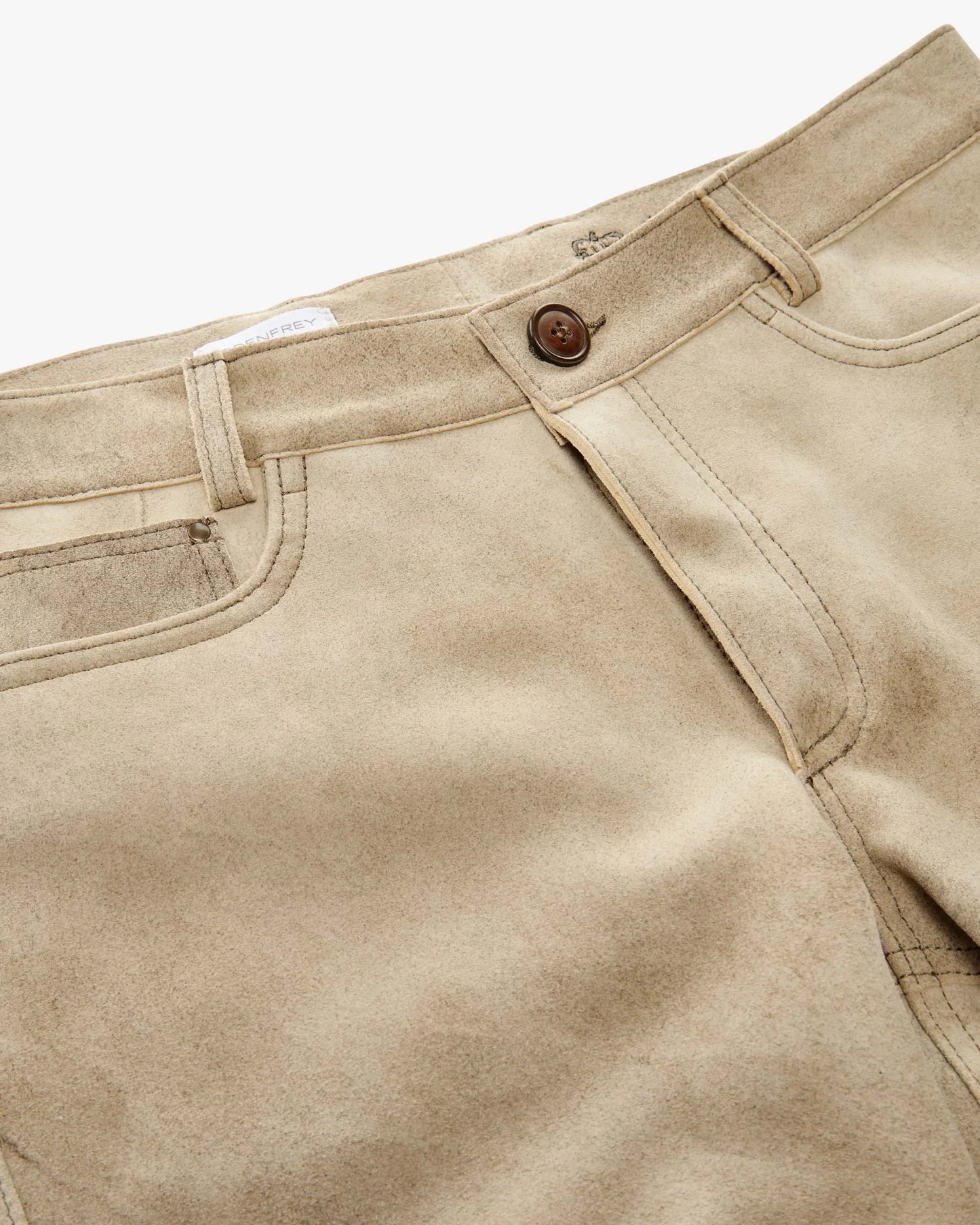Close-up of beige pants with a button on a white background