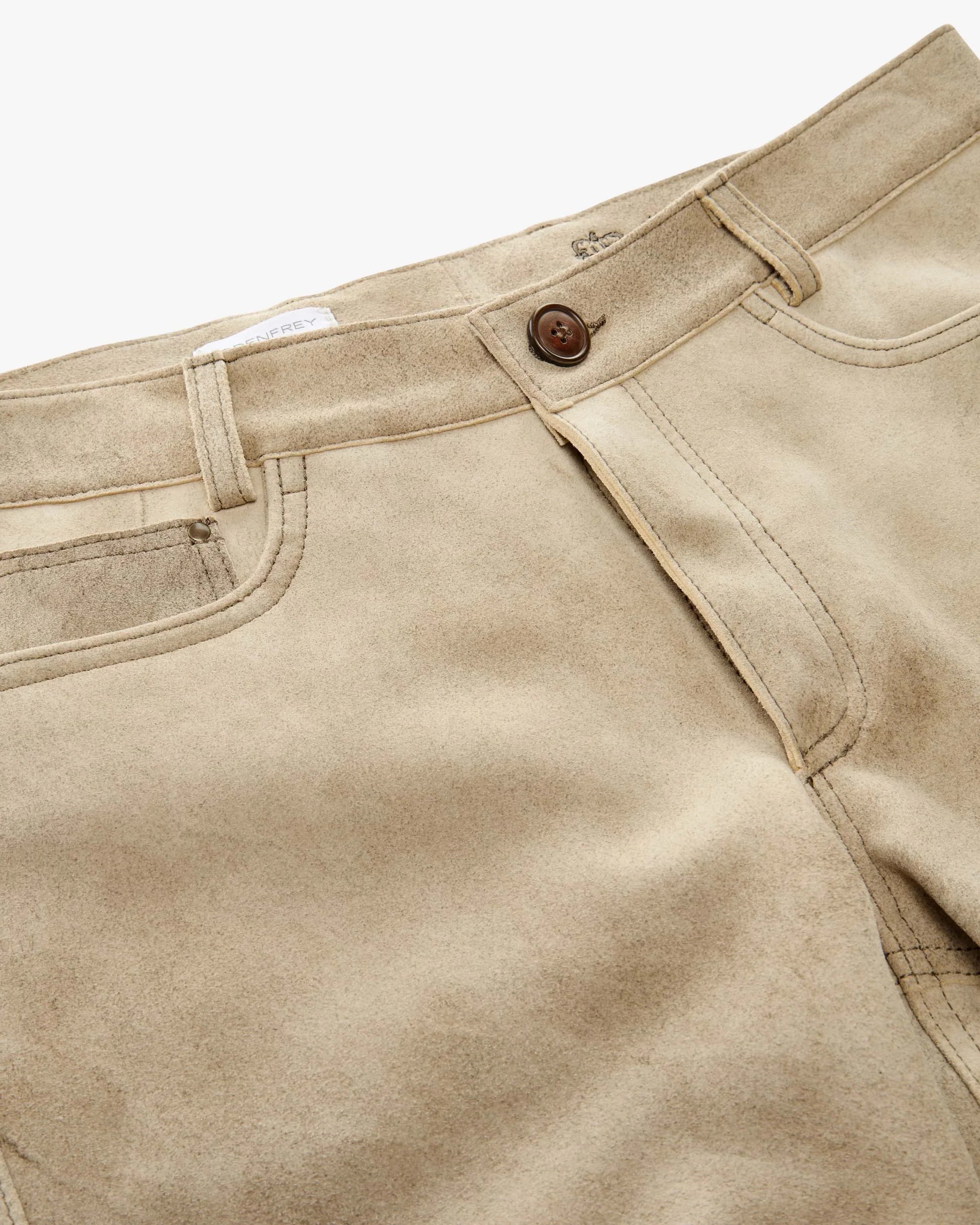 Close-up of beige pants with a button on a white background