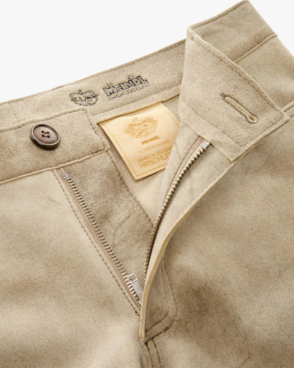 Close-up of beige pants with brand label and button details