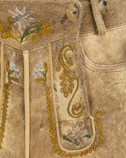 Close-up of embroidered fabric with floral patterns on a beige background