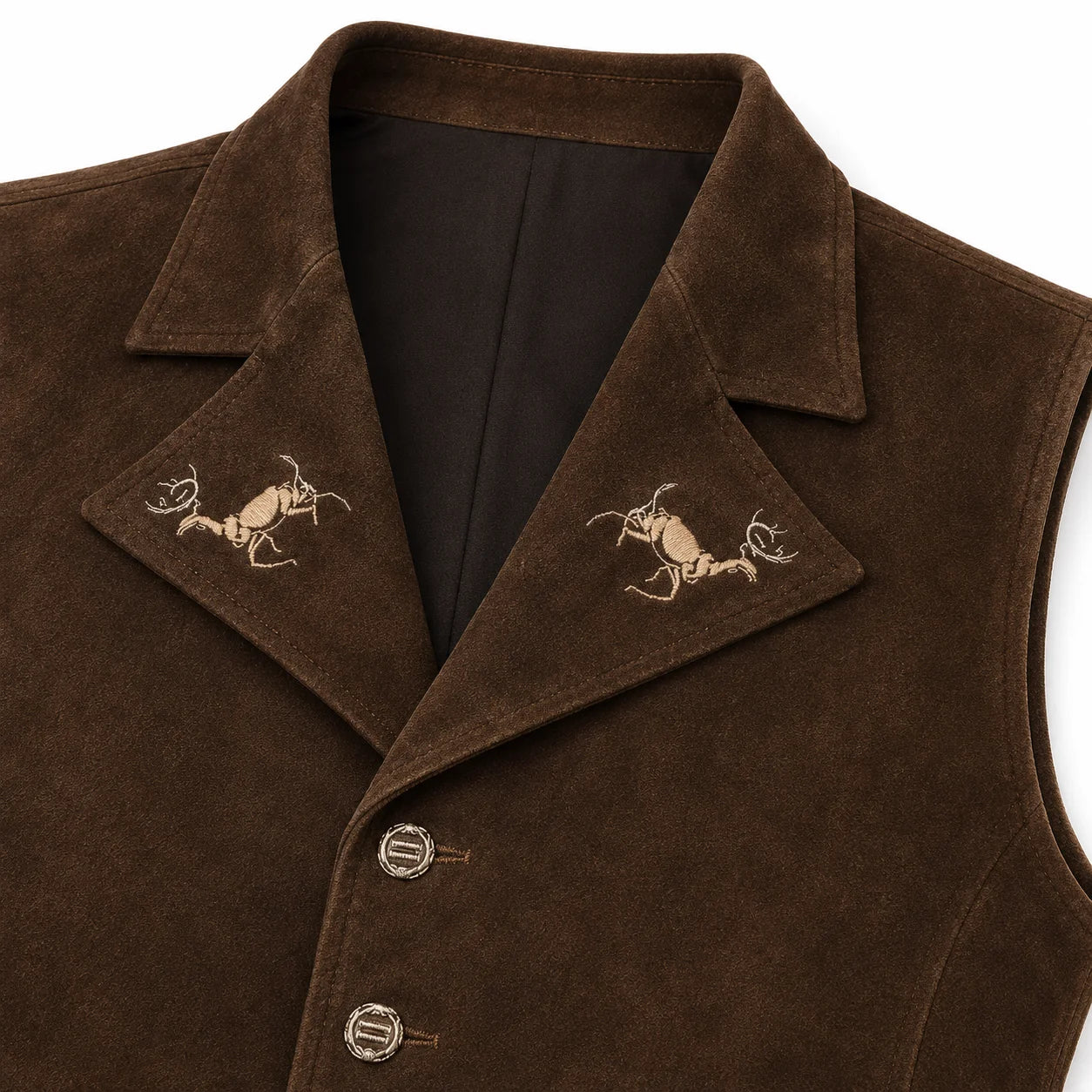 Close-up of a brown suede vest with notched lapels featuring embroidered deer motifs on each side, a dark brown inner lining, and decorative buttons on the front.