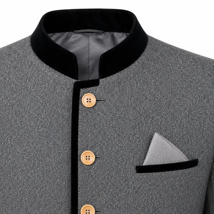 Close-up of a gray textured jacket with a black mandarin collar, black trim, and light brown buttons, featuring a matching gray pocket square with a black band.