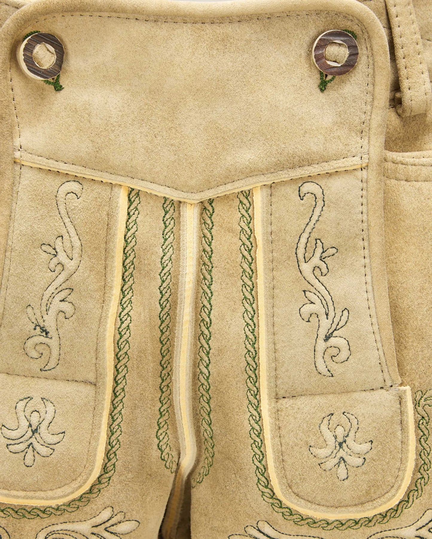 Close-up of beige fabric with intricate green embroidery