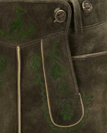 Brown leather jacket with green embroidered designs on a dark background
