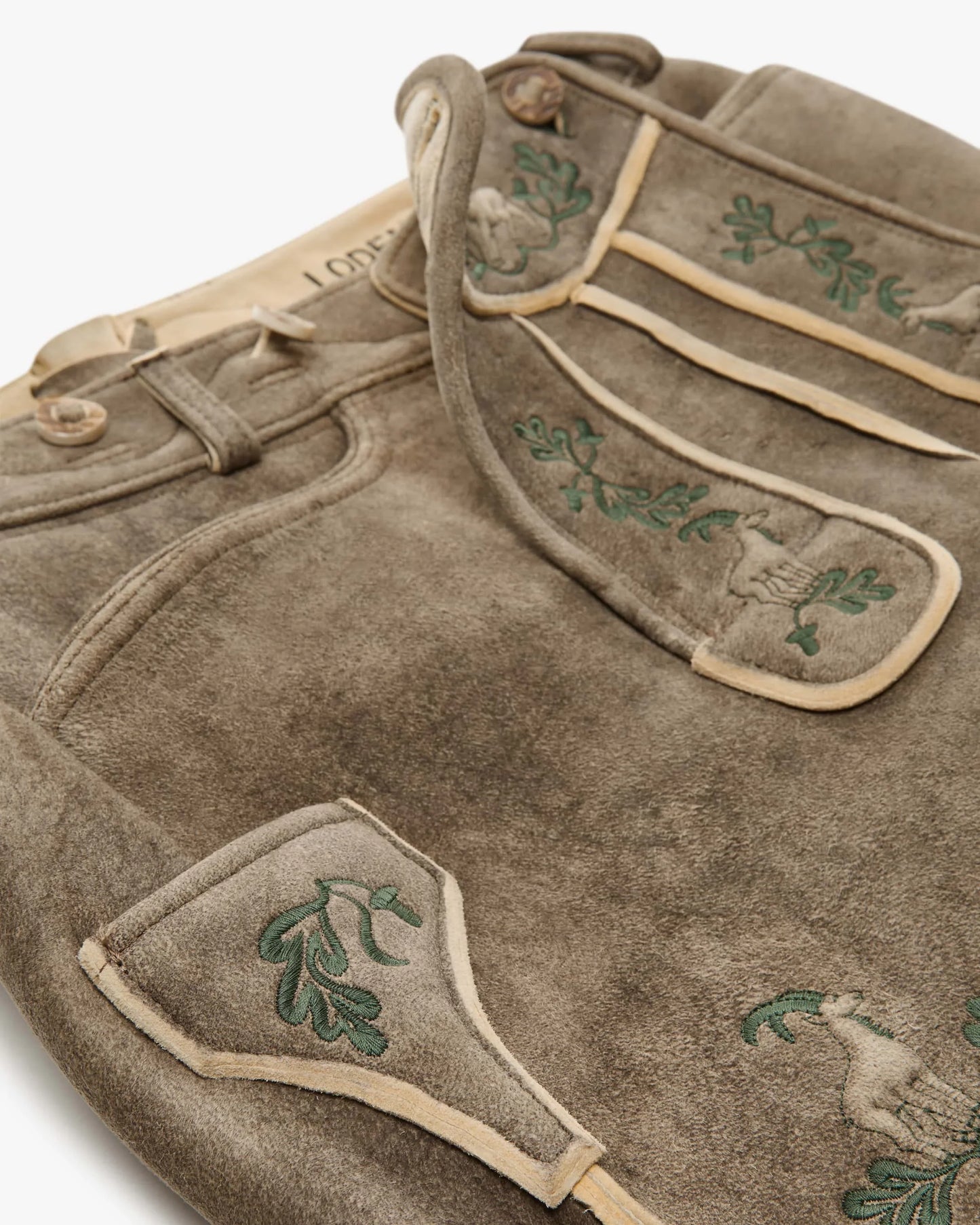 Brown leather apron with green embroidery on a white background