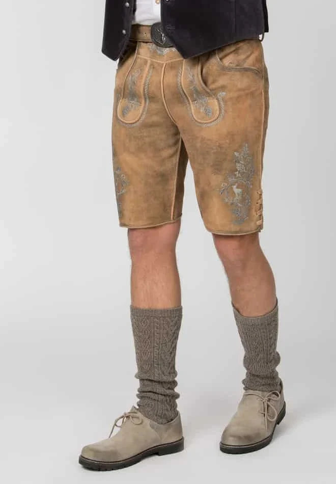 Person wearing traditional Bavarian lederhosen with embroidered details on a white background