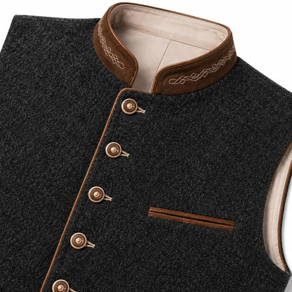 Close-up of a dark charcoal gray wool vest with brown suede-like trim, decorative embroidery on the collar, and metallic buttons, shown on a white background.