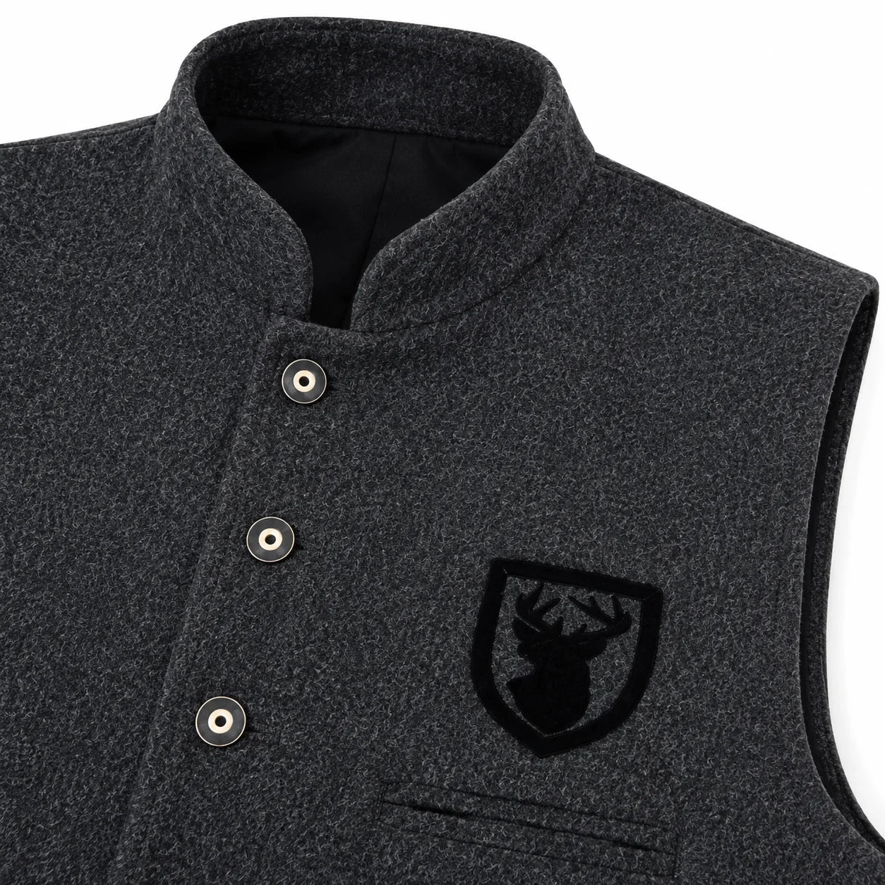 Close-up of a dark heather gray wool vest with a mandarin collar, snap-button placket, and a black embroidered shield logo patch on the chest.