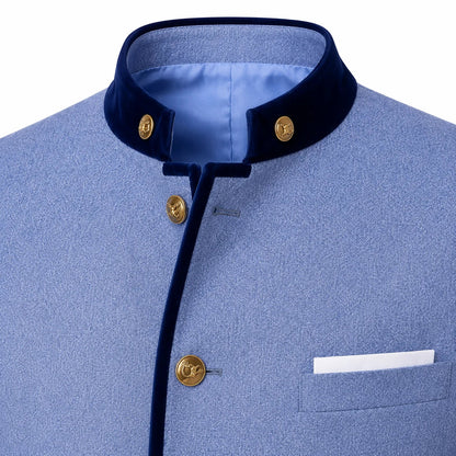 A close-up of a light blue textured jacket with a contrasting dark navy velvet stand collar and front trim, accented by gold buttons and a white pocket square.