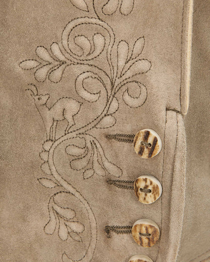 Close-up of a beige fabric with floral embroidery and buttons.