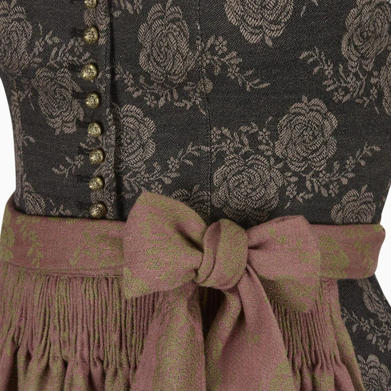 Close-up of a traditional dirndl with floral pattern and fringed belt