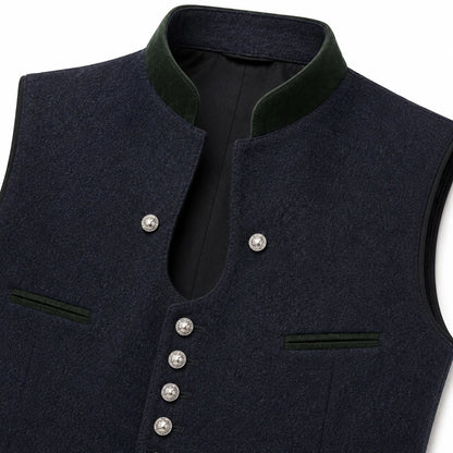 Close-up of a dark navy wool vest with a high dark green corduroy collar, silver-tone snap buttons, and welt pockets on a white background.