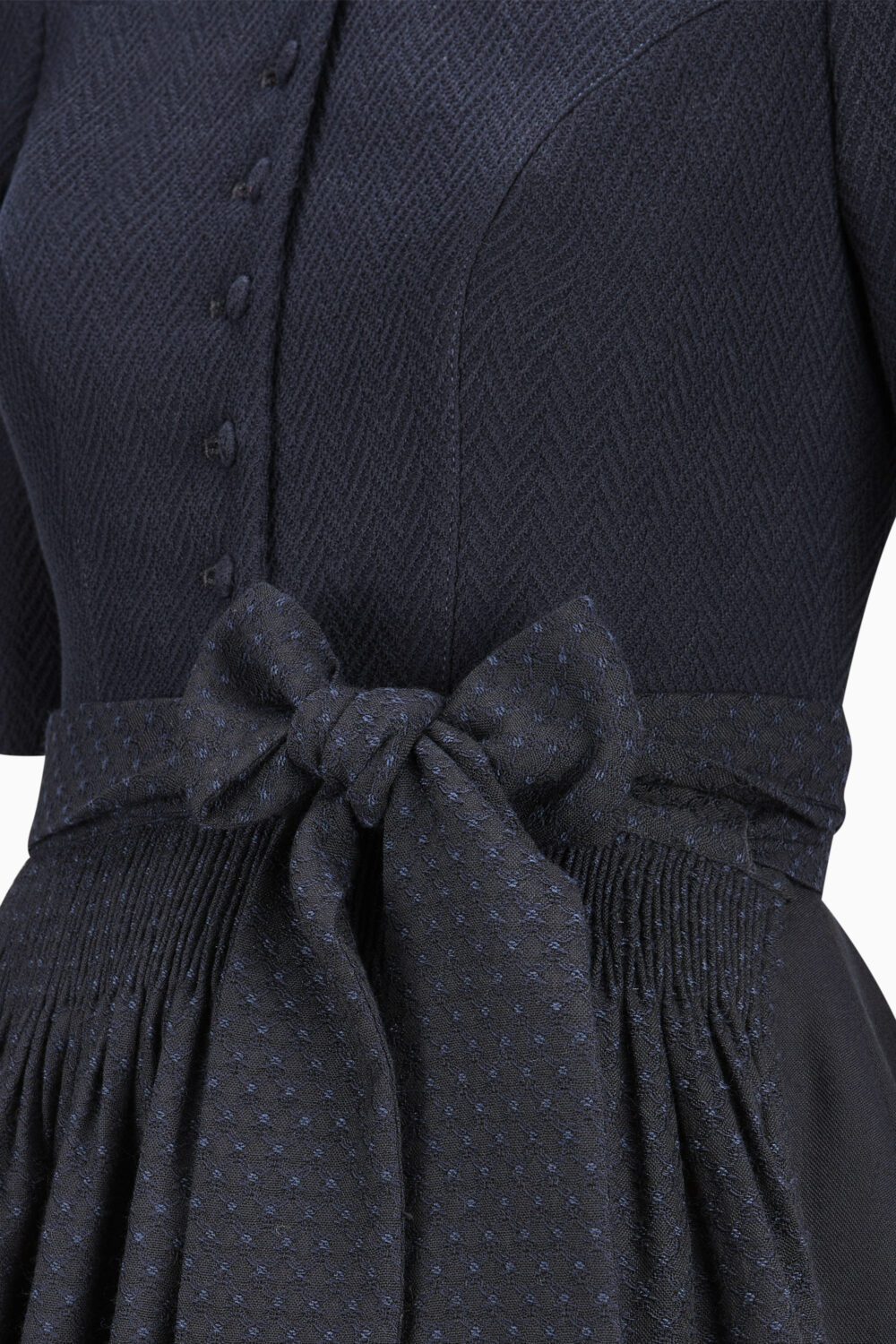 Navy blue dress with a bow detail on a white background