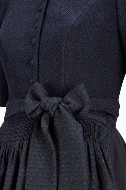 Navy blue dress with a bow detail on a white background