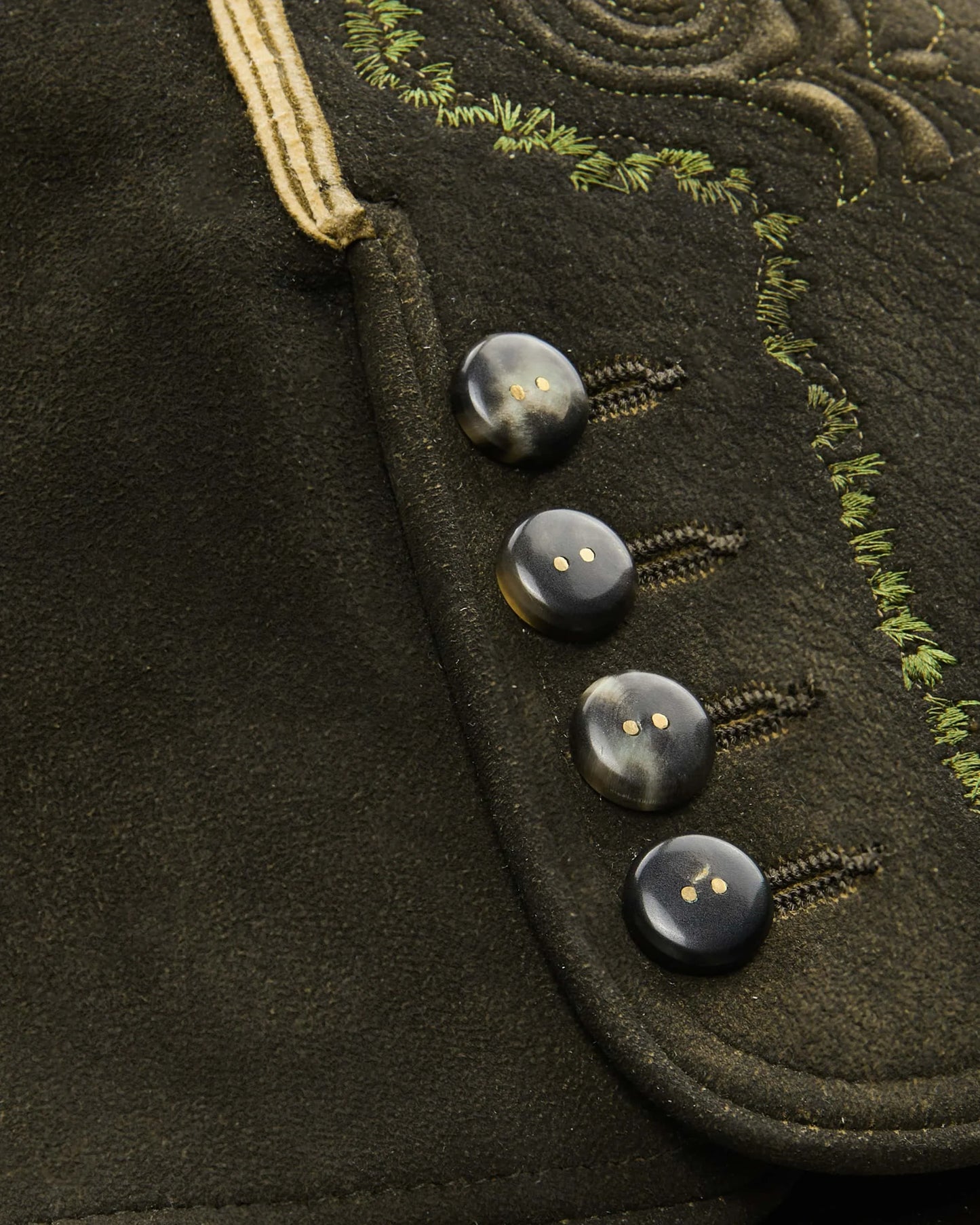 Traditional black leather shorts with gold embroidery on a white background