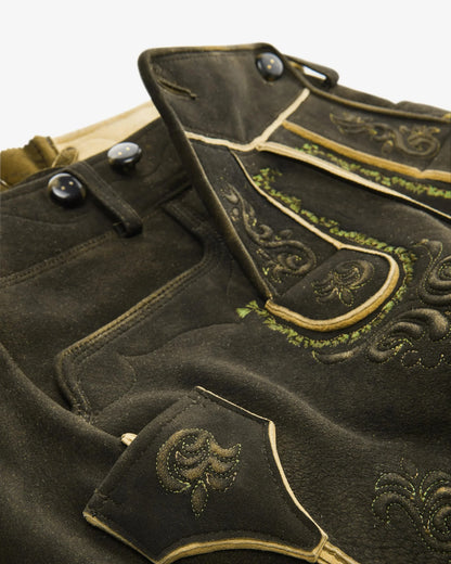 Traditional black leather shorts with gold embroidery on a white background