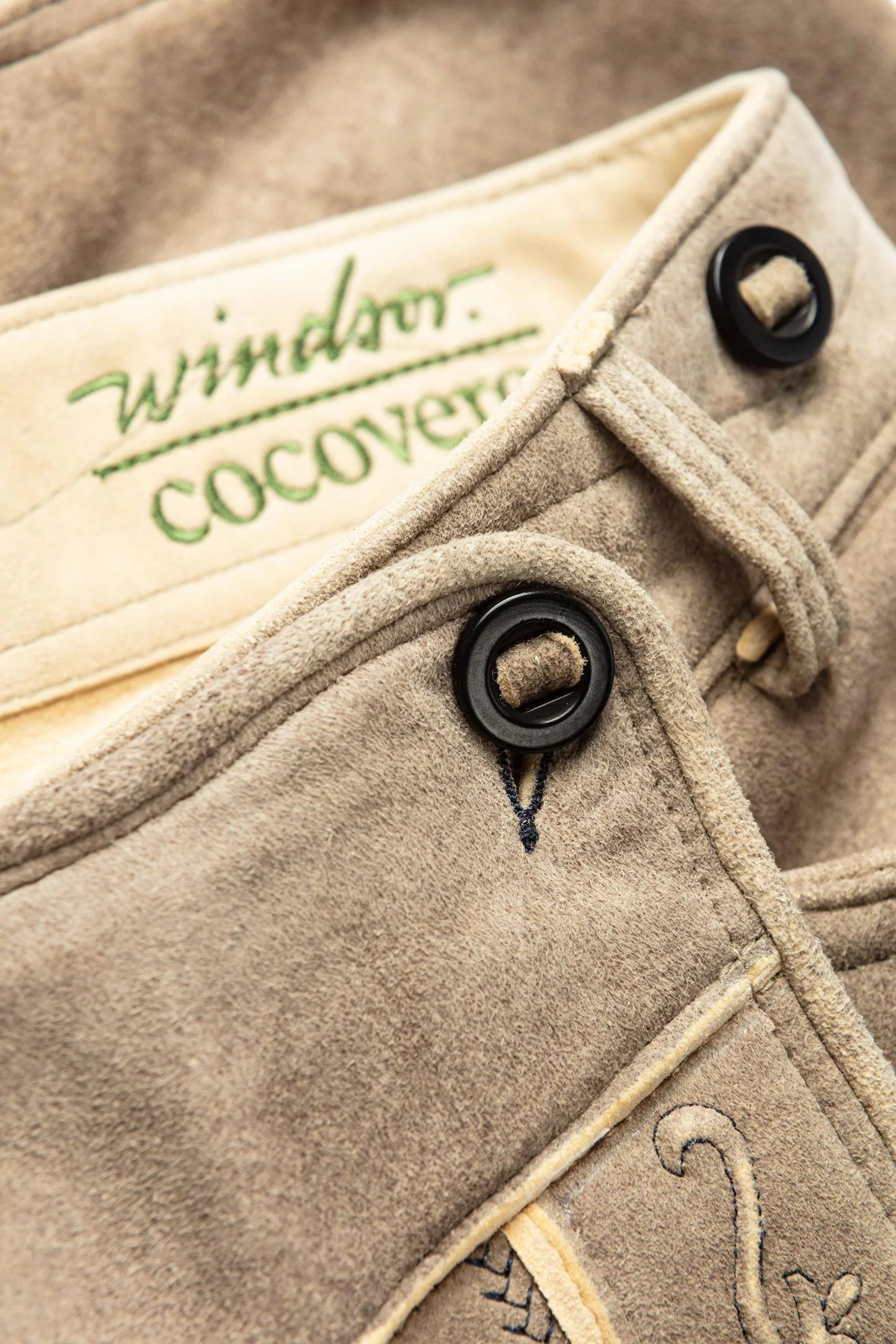 Close-up of a beige fabric with 'Windsor Cocover' branding and black buttons.