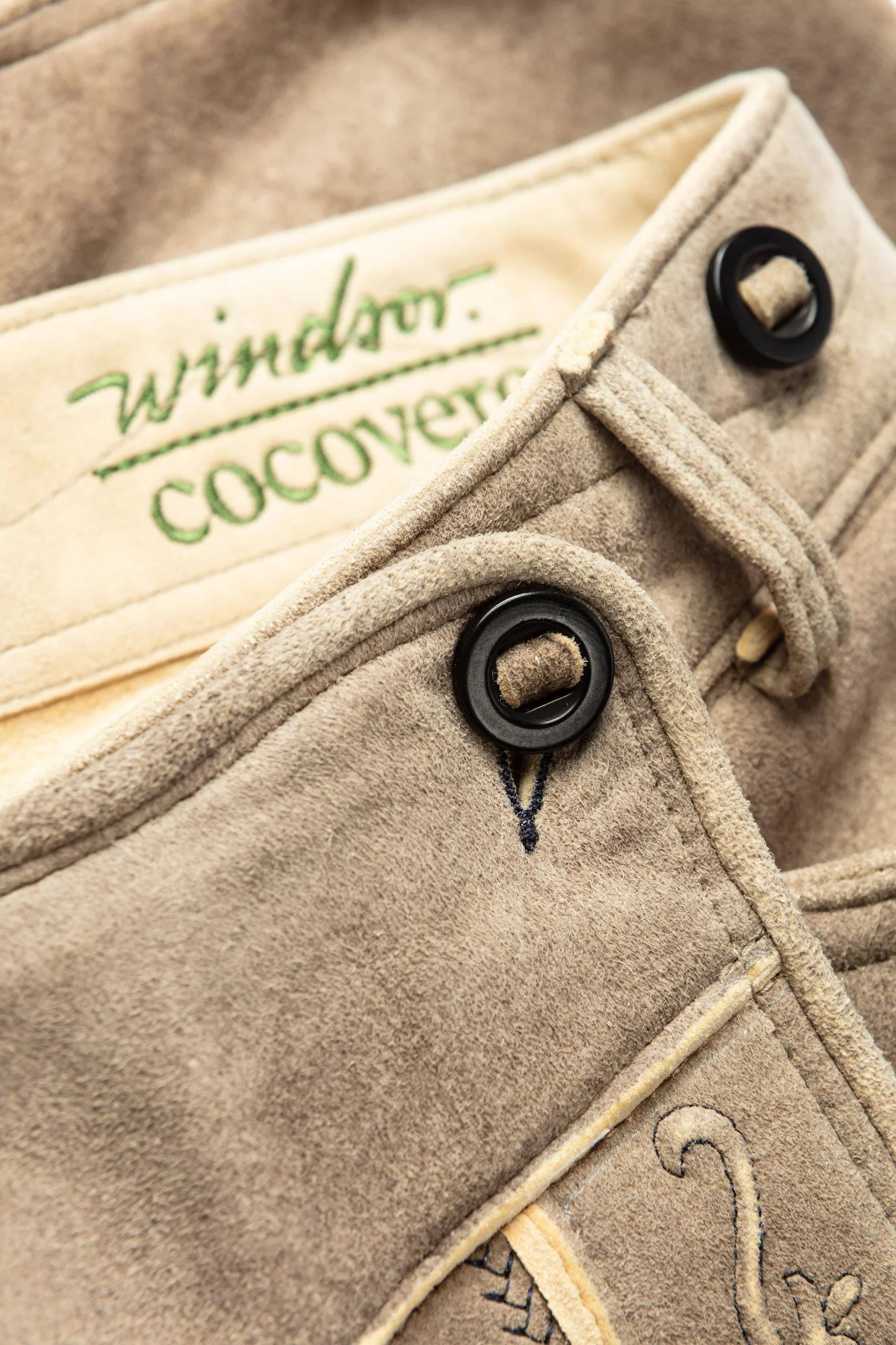 Close-up of a beige fabric with 'Windsor Cocover' branding and black buttons.