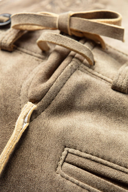Close-up of a brown coat with a belt and button details