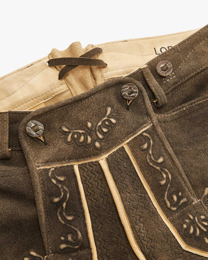 Close-up of a brown leather belt with decorative buckle and stitching details.